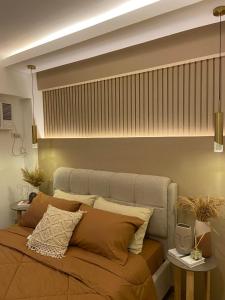 a bedroom with a large bed with pillows at Luxury 1 BR Suite Near NAIA in Manila