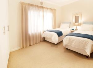 una camera da letto con due letti e una finestra di Chalet 40 Plettenberg Bay A tranquil location with beach access in large grounds ideal for families a Plettenberg Bay Altre 62 foto