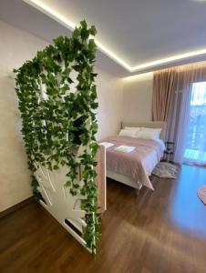 a bedroom with a large plant growing up the wall at Apartmani Montis Zlatibor in Zlatibor