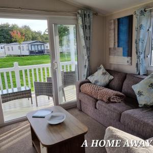 a living room with a couch and a table and a balcony at A HOME AWAY AT Tattershall country park in Tattershall