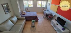 a living room with a couch and a bed at Departamento Allegretto Monoambiente in San Luis