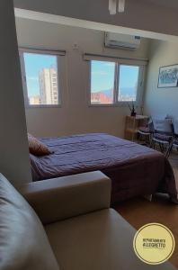 1 dormitorio con 1 cama grande y 2 ventanas en Departamento Allegretto Monoambiente en San Luis