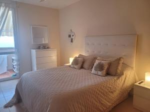 a bedroom with a white bed with pillows and a window at Gran View Apartment Sea Wiew, WiFi,Garage, Car rental in Adeje +39 photos