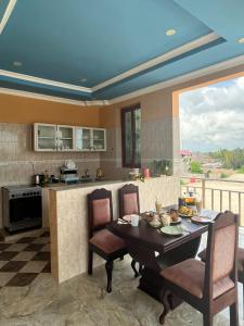 a kitchen with a table with chairs and a counter top at Stardust Villa - ** Hotel in Paje