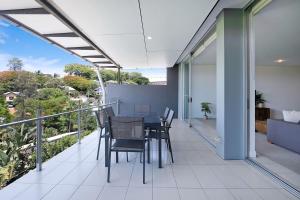 a balcony with a table and chairs on it at Treetop Horizons - Experience Red Hills Local Vibe in Brisbane