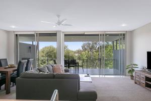 a living room with a couch and a table at Treetop Horizons - Experience Red Hills Local Vibe in Brisbane