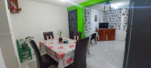 ein Esszimmer mit einem Tisch und einer grünen Wand in der Unterkunft CASA AMPLIA TODOS LOS SERVICIOS in Mexiko-Stadt