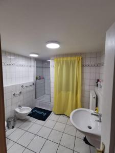 ein Badezimmer mit einem gelben Duschvorhang und einem Waschbecken in der Unterkunft EG Wohnung mit eigenem Eingang in Recklinghausen