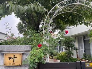 Un cartello su un muro con dei fiori in un cortile di 叶 a Nishikichō