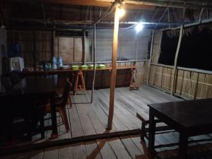 een kamer met een houten vloer, een tafel en een licht bij Sunset homestay in Besir