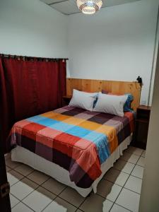 - une chambre avec un lit et une couverture colorée dans l'établissement Granja Triple A, à Guatemala