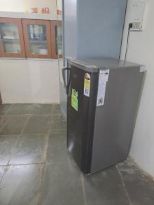 a refrigerator sitting on the floor in a room at Private Farm Stay in Pune