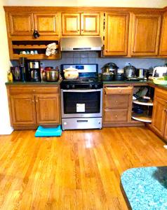 a kitchen with a stove and a wooden floor at B1 A private room in Naperville downtown with desk and Wi-Fi near everything in Naperville