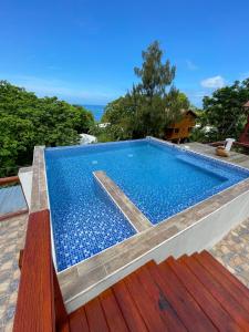 a swimming pool with blue tiles on a house at Villas De Cisnes Starfish or Anchor floors in Roatan