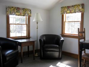 a room with two chairs and a table and two windows at The Chatham Motel in Chatham