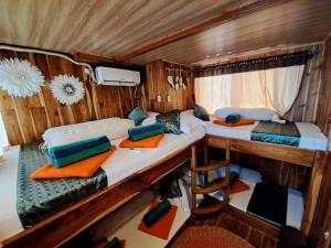 a small room with two beds and a desk at Tour komodo in Labuan Bajo