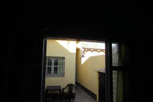 een kamer met een raam en een tafel en stoelen bij Hostel Céntro Belén in Belén