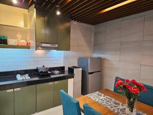 a kitchen with a table with a vase of red flowers at Kai Lodge by the Hill 2 in Baguio
