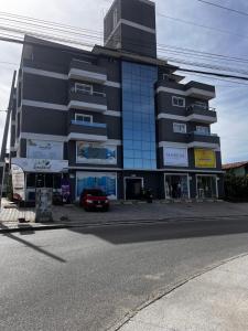 um edifício preto com um carro estacionado em frente em Apartamento Ingleses para Casal 102 em Florianópolis