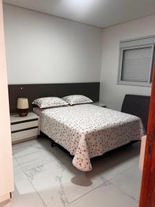 um quarto com uma cama com um cobertor de bolinhas em Apartamento Ingleses para Casal 102 em Florianópolis
