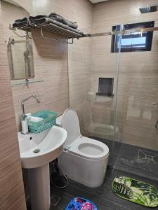 a bathroom with a toilet and a sink and a shower at Kai Lodge by the Hill 2 in Baguio
