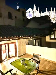 a green table and a chair on a patio at Apartamento Canónigo - terraza con vistas in Toledo