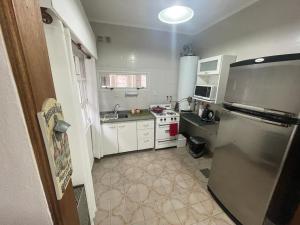 a kitchen with a stainless steel refrigerator and white cabinets at en lo de Pancho 2 in Río Gallegos