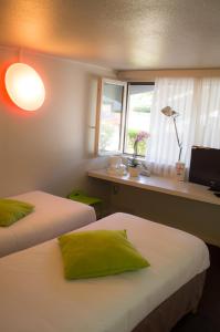 A bed or beds in a room at Campanile Villeneuve-Sur-Lot