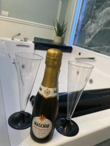 una bottiglia di champagne e due bicchieri su un bancone di Sunny Suite Napoli a Napoli