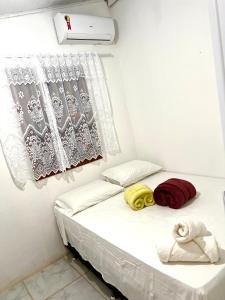 a small bedroom with a bed with towels on it at Casa 02 na villa uryah in Caraíva
