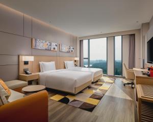 Pokój hotelowy z łóżkiem i biurkiem w obiekcie Hyatt Place Chengdu Bio-Town w mieście Chengdu