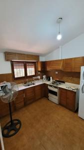 une cuisine avec des armoires en bois et un réfrigérateur blanc dans l'établissement Casa Rumipal, à Villa Rumipal