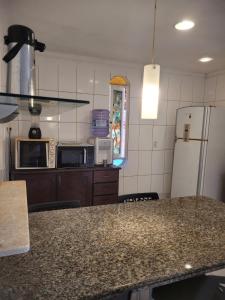 a kitchen with a counter top and a refrigerator at Perobas beach house in Touros