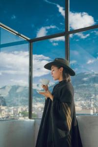 una mujer con un sombrero sosteniendo una taza de café en Marzano en Cajamarca
