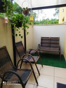 two chairs and a bench on a balcony at Loft aconchegante e funcional no Campeche in Florianópolis