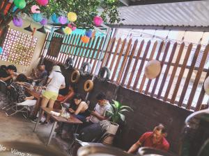 a group of people sitting at tables in a restaurant at Homestay GÁC MƠ Vũng Tàu in Vung Tau