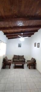 a living room with two benches and a ceiling at Cabaña Nde Roga in Colonia Carlos Pellegrini