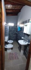 a bathroom with a sink and a toilet and a sink at Cabaña Nde Roga in Colonia Carlos Pellegrini