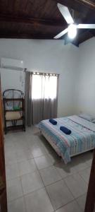 a bedroom with a bed and a ceiling fan at Cabaña Nde Roga in Colonia Carlos Pellegrini