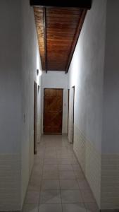 a hallway with a wooden door and a tile floor at Cabaña Nde Roga in Colonia Carlos Pellegrini
