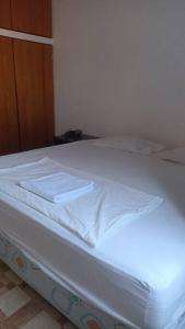 - un lit blanc avec des draps blancs et des serviettes dans l'établissement alquiler departamento amoblado., à Tarapoto