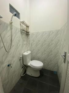 a bathroom with a toilet and a shower at Resy home syariah dekat alun2 wonosobo in Kalianget