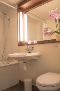 a bathroom with a sink and a toilet and a mirror at Campanile Villeneuve-Sur-Lot in Pujols Lot et Garonne