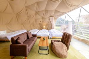 a living room with two beds in a tent at glampark Mashikokan Tochigi in Mashiko