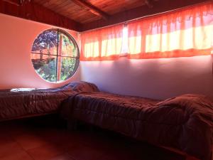 two beds in a room with a window at Don Martin in El Bolsón