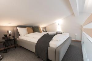 a bedroom with a large bed with white sheets at Spirit Apartments Suites in Brienz +24 photos