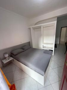 a bedroom with a large bed and a shelf at Casa Cor de Rosa in Praia