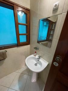uma casa de banho com um lavatório e um espelho em Casa Cor de Rosa em Praia