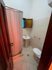 uma casa de banho com um WC e um lavatório em Casa Cor de Rosa em Praia