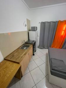 eine kleine Küche mit Spüle und Kühlschrank in der Unterkunft Casa Cor de Rosa in Praia